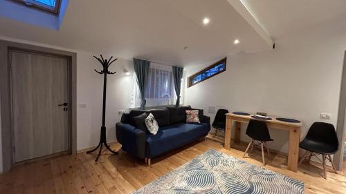 a living room with a blue couch and a table at La Casa Verde in Buşteni