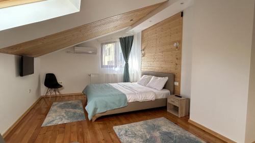 a small bedroom with a bed and a window at La Casa Verde in Buşteni