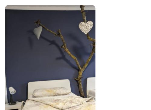 a bedroom with a tree with hearts on the wall at Feel Like Home - MeTime2 in Frielendorf