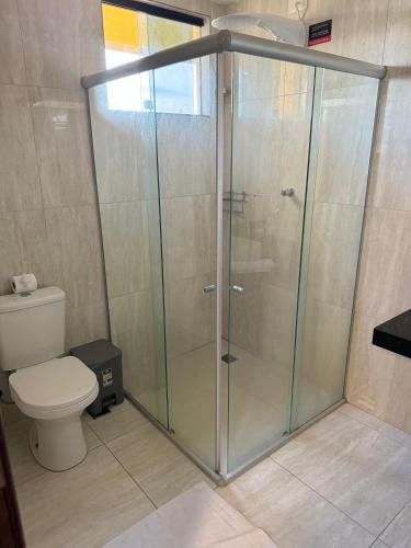 a glass shower in a bathroom with a toilet at Pousada Elo Inn in Recife