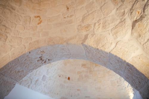 a stone archway in a building with a brick wall at Trulli Magravì - Apparthotel in Alberobello