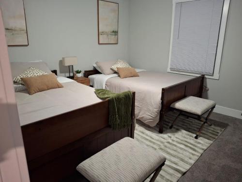 a bedroom with two beds and a chair and a window at Luxury 4 Large Bedrooms with 5 Beds and 3 Baths, a Quiet Street in Cascade Area in Atlanta