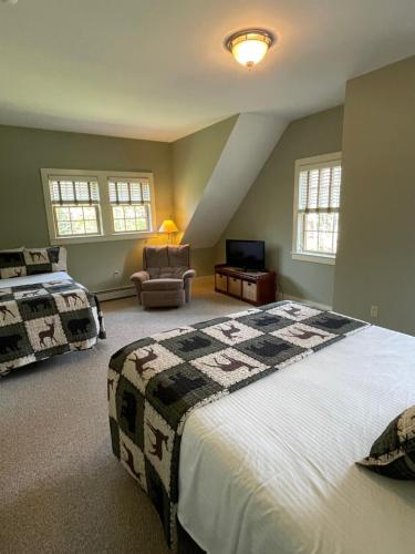 a bedroom with a king sized bed and a chair at The Snowed Inn in Killington