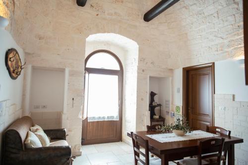 a living room with a table and a window at Trulli Magravì - Apparthotel in Alberobello