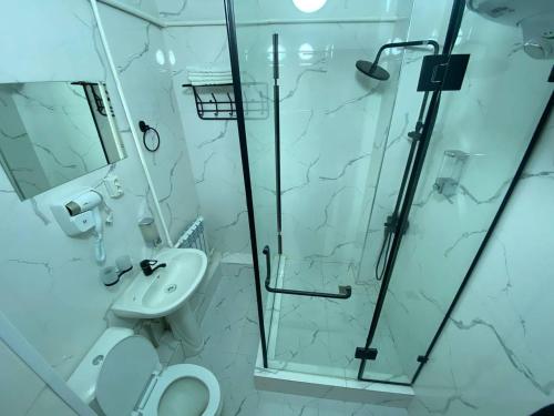 La salle de bains est pourvue d'une douche, de toilettes et d'un lavabo. dans l'établissement Bagysh Hotel, à Kochkorka