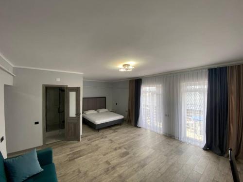 - un salon avec un lit et un canapé dans l'établissement Bagysh Hotel, à Kochkorka