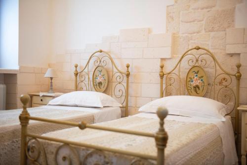 a bedroom with two beds with white pillows at Trulli Magravì - Apparthotel in Alberobello