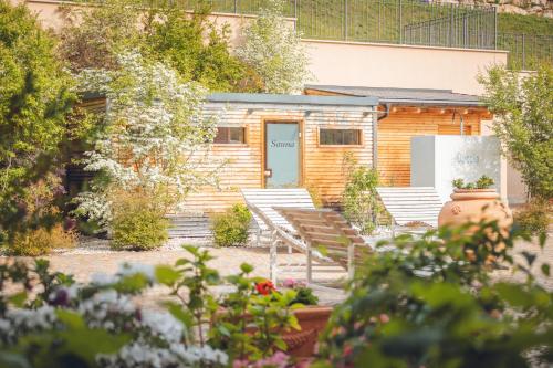 a building with a bunch of chairs in a garden at Agriturismo La Pertica in Costermano sul Garda
