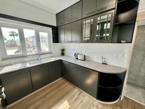 a kitchen with black and white cabinets and a sink at Elegant penthouse in Limassol in Limassol