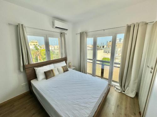 a bedroom with a bed and a large window at Elegant penthouse in Limassol in Limassol