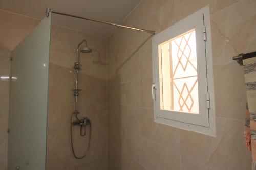 a shower with a window in a bathroom at Amour Sénégal in Ngaparou