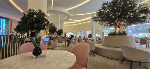 een restaurant met tafels, stoelen en bomen erin bij The Star in Dubai