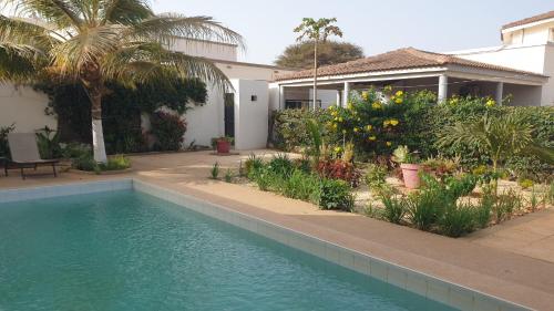 a swimming pool in front of a house at Amour Sénégal in Ngaparou