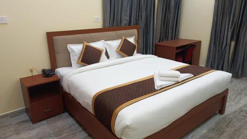 a bedroom with a large bed with two night stands at Hotel Kashyaam Inn in Varanasi