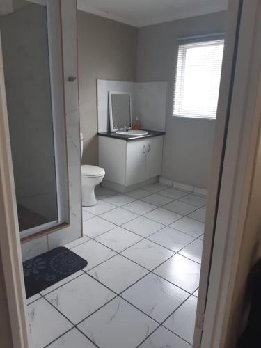 ein weißes Bad mit einem WC und einem Waschbecken in der Unterkunft The Getaway in Port Alfred