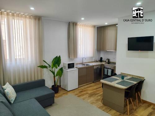 a living room with a couch and a kitchen at Casa Central D'ouro in Tabuaço