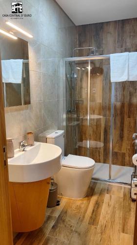 a bathroom with a sink and a shower and a toilet at Casa Central D'ouro in Tabuaço