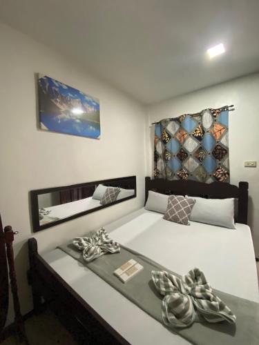 a bedroom with a large white bed and a mirror at Dreamland budget room in El Nido