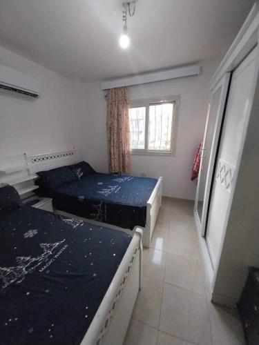 a bedroom with two beds and a window at TAVIRA Rass Suder"For Family" in Raʼs Matarma