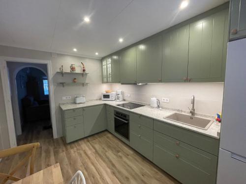 a kitchen with green cabinets and a sink at Villa Suérte del Mar in Torrevieja