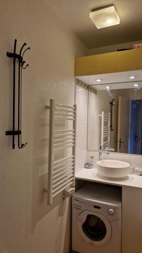 une salle de bain avec une machine à laver et un lavabo dans l'établissement Superbe Appartement avec Vue Panoramique, à La Baule