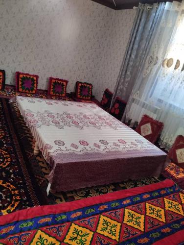 ein großes Bett in einem Zimmer mit einem Teppich in der Unterkunft Eshinbay in Sary-Mogul