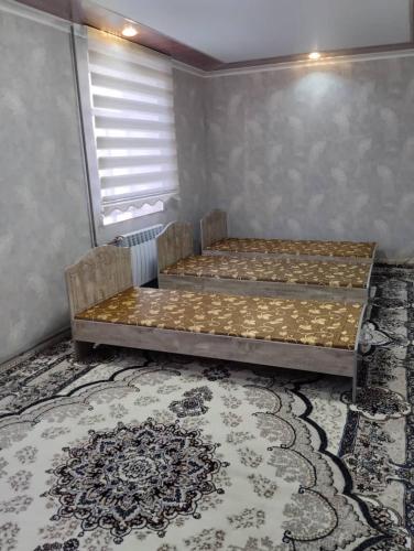 1 Schlafzimmer mit 2 Betten und einem Teppich in der Unterkunft Eshinbay in Sary-Mogul