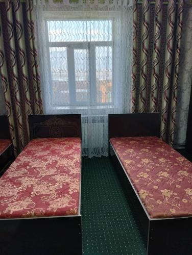 2 Betten in einem Zimmer mit Fenster in der Unterkunft Eshinbay in Sary-Mogul