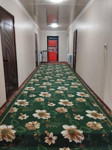 einen Flur mit grünem Teppich mit Blumen drauf in der Unterkunft Eshinbay in Sary-Mogul