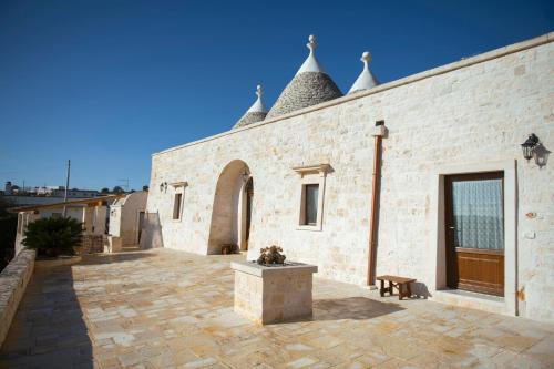 a brick building with a courtyard with a bench at Trulli Magravì - Apparthotel in Alberobello
