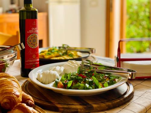 una mesa con un plato de comida y una botella de vino en Stagnone Area Zero en Birgi Vecchi