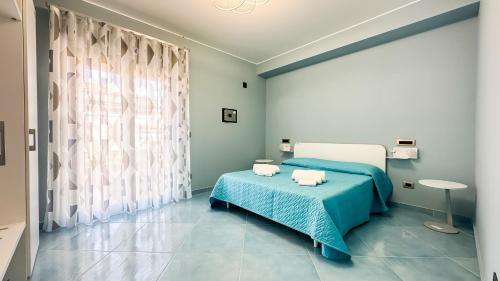 Un dormitorio con una cama azul y una ventana en After Sun, en Patti