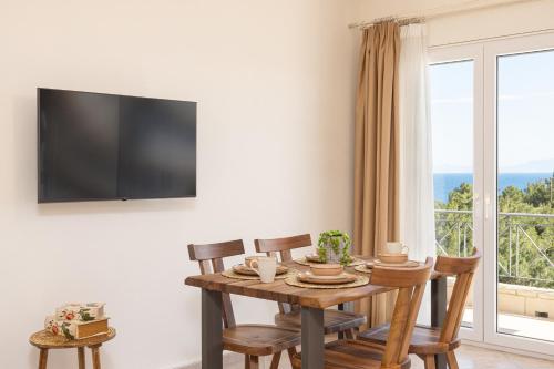 a dining room with a table and chairs and a window at PENNY LUXURY APARTMENTS in Kokkari