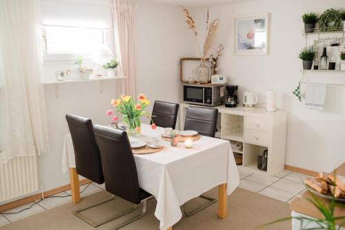 - une salle à manger avec une table et des chaises dans l'établissement BUCHLINDENWEG - Zimmer & Ferienwohnung, à Breitscheid