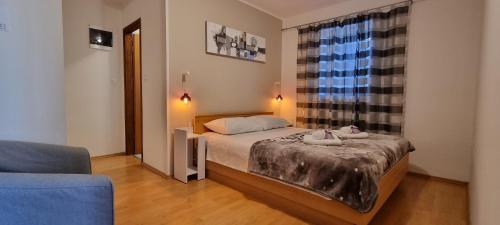 um pequeno quarto com uma cama e uma janela em Apartment Rajci em Cres