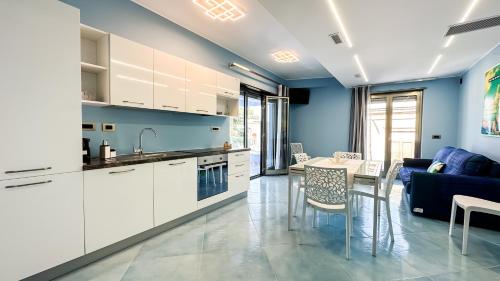 una cocina con armarios blancos y una pared azul en After Sun, en Patti