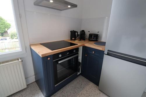 Il comprend une petite cuisine équipée d'une cuisinière et d'un évier. dans l'établissement Appartement 3 chambres - Proche centre-ville Nevers, à Coulanges-lès-Nevers