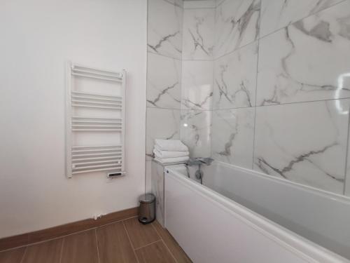 La salle de bains blanche est pourvue d'une baignoire et d'un miroir. dans l'établissement Toulouse Saint Georges SG3, T3, 2ch terrasse Pk, à Toulouse