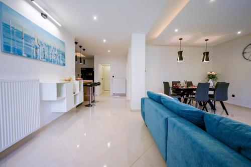 Una sala de estar con un sofá azul y un comedor. en Lady D, en Betina