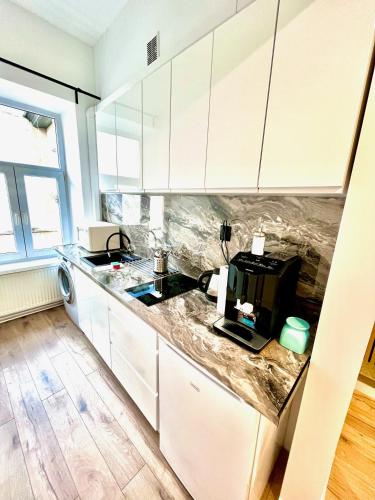 a kitchen with white cabinets and a counter top at Pokoje Gościnne Wiślna in Krakow