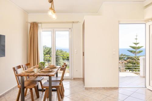 a dining room with a table and chairs and a large window at PENNY LUXURY APARTMENTS in Kokkari