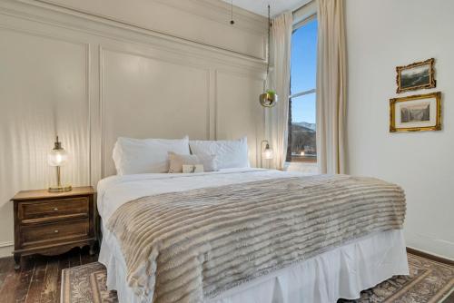 a white bedroom with a large bed and a window at The Historic Grand Canyon Hotel in Williams