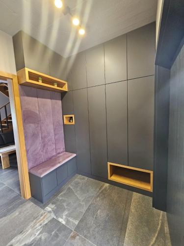 a dressing room with a purple bench in a room at Dom w Czerwonej Dolinie Haus im Roten Tal Seidorf Sosnówka` in Sosnówka