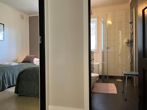 a bedroom with a bed and a bathroom with a toilet at Bosdalhuset in Lavik