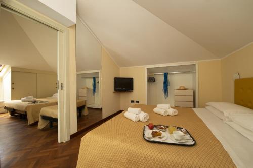 ein Hotelzimmer mit einem Tablett mit Essen auf dem Bett in der Unterkunft Hotel Milano in Cesenatico