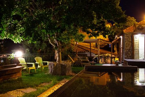 Casa do Ribeirinho في أمارانتي: حديقة خلفية بالليل فيها كراسي وشجرة