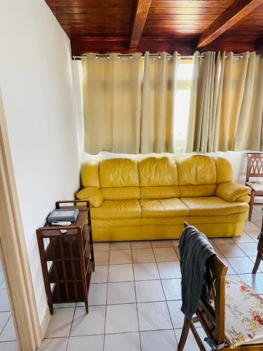 um sofá amarelo numa sala de estar com uma janela em Arobba em Villaggio Mosè