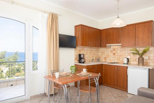 a kitchen with wooden cabinets and a table with chairs at PENNY LUXURY APARTMENTS in Kokkari