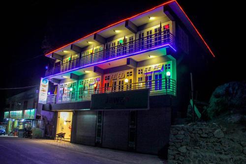 un edificio con luces de colores por la noche en Al Jannat Hotel & Relax Inn Guest House Skardu en Skardu