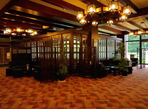 a lobby with a large room with plants in it at Nozawa Grand Hotel in Nozawa Onsen